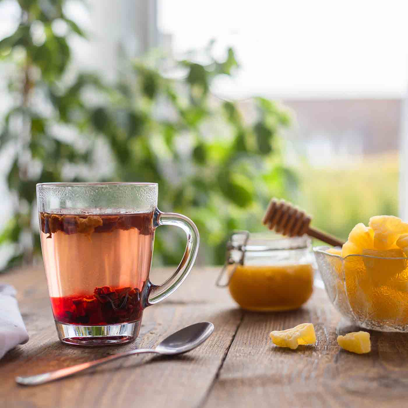 Glas Tee mit einer Schale Ananasstueckchen Fun Fact Produkt Ananas Tropenglueck Tee online kaufen bei Genussio