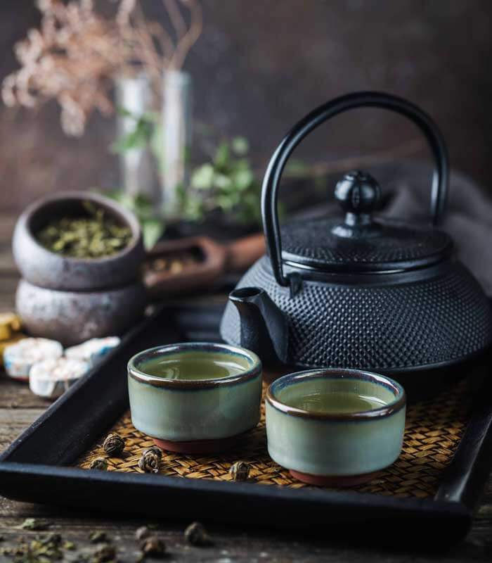 Teetasse und Teekanne mit frischem Tee Bio Kraeutertee Genussio jetzt online kaufen