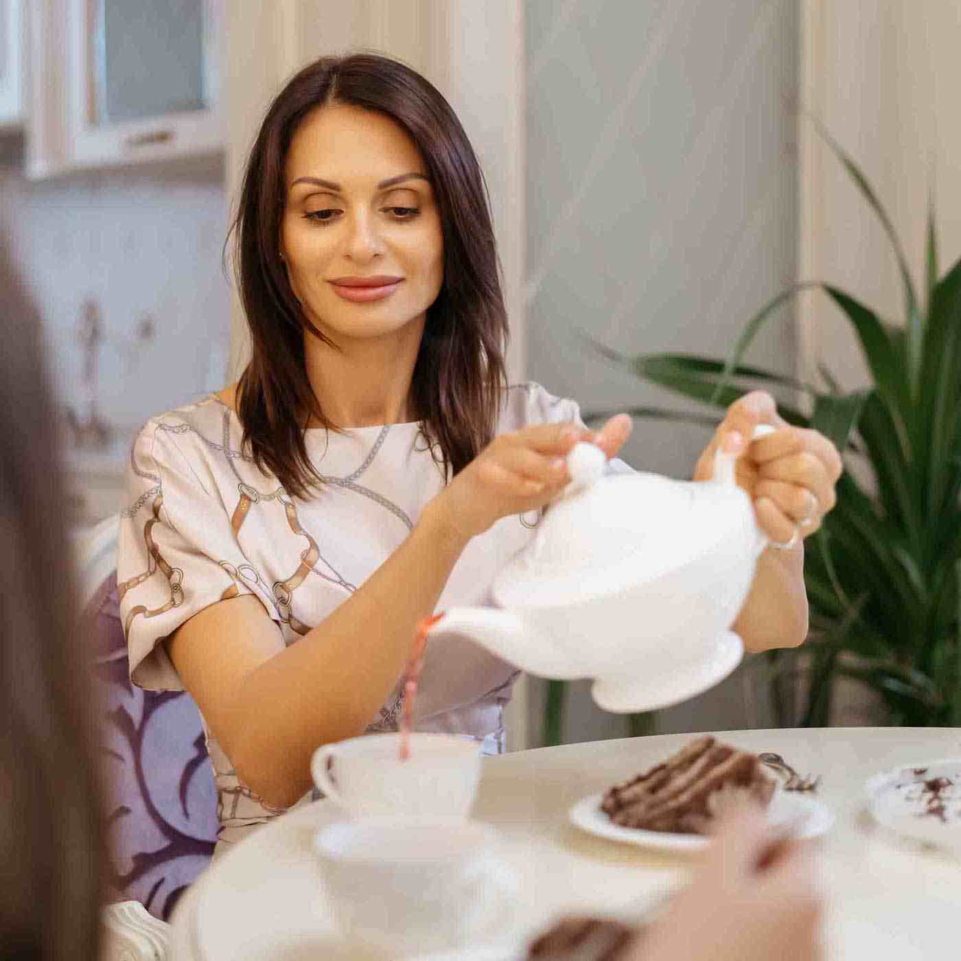 Frau gießt sich eine Tasse Tee ein Fun Fact Produkt Teeschaufel online kaufen bei Genussio