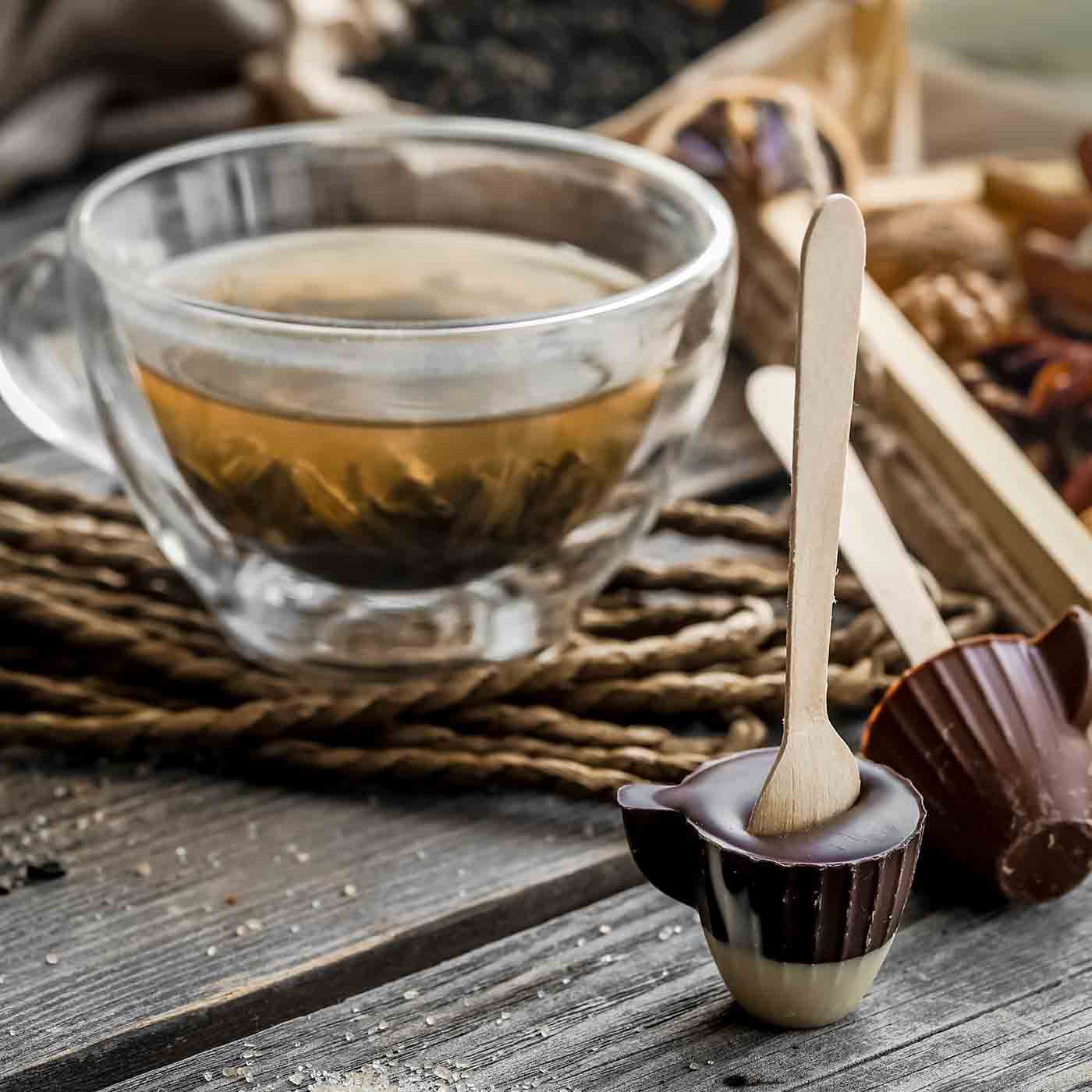 Eine Tasse Tee daneben ein Loeffel mit Schokolade Fun Fact Produkt Trueffel Schokotraum Tee online kaufen bei Genussio